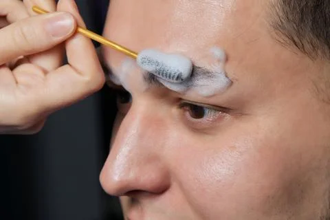 Professional barber doing threading procedure and correcting shape of eyebrows Stock Photos