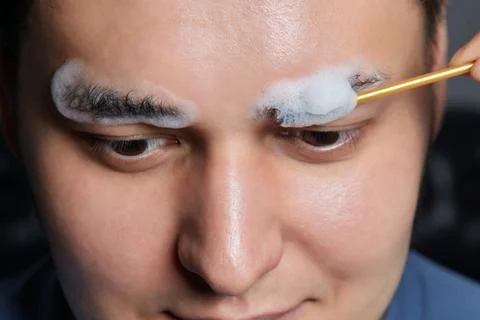 Professional barber doing threading procedure and correcting shape of eyebrows Stock Photos