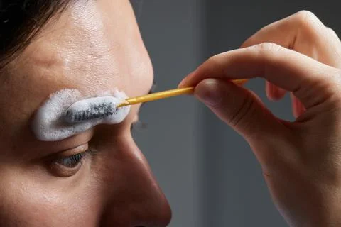 Professional barber doing threading procedure and correcting shape of eyebrows Stock Photos