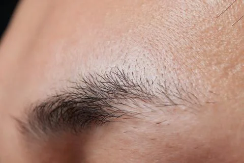 Professional barber doing threading procedure and correcting shape of eyebrows Stock Photos