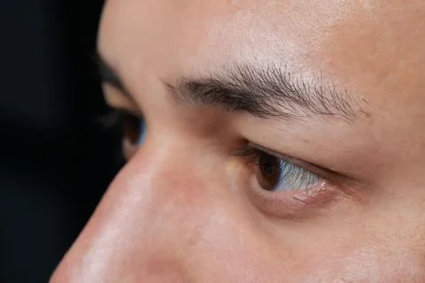 Professional barber doing threading procedure and correcting shape of eyebrows Stock Photos