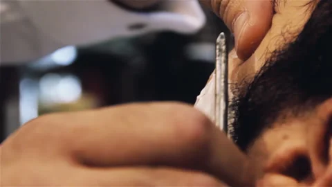 Professional Barber Shaving Client Beard with Blade and White Foam - 4K Stock-Footage 337646480