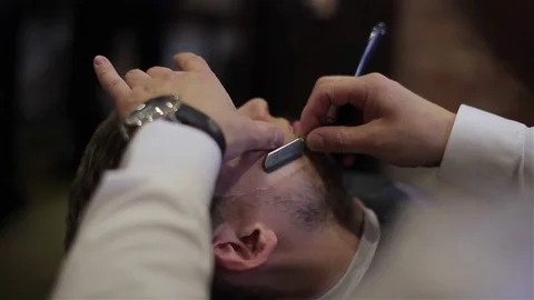 Professional barber use old-school razor with blade to shave happy client man  Stock Footage 69764192