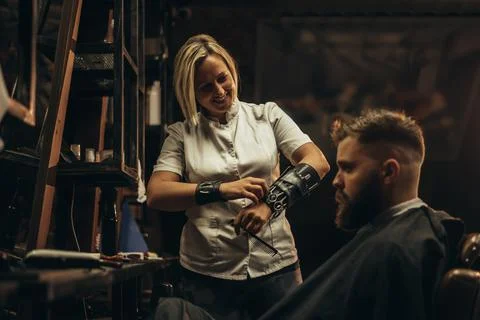 Professional barber wearing her tools on the forearm and working in her barbe Stock Photos