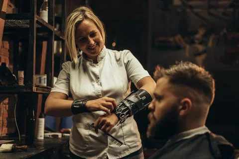 Professional barber wearing her tools on the forearm and working in her barbe Stock Photos