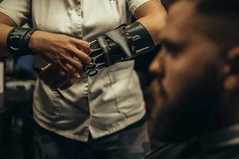 Professional barber wearing her tools on the forearm and working in her barbe Stock Photos