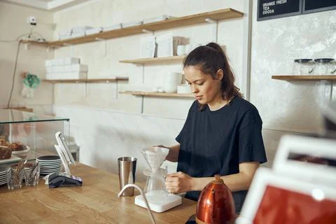 Professional barista preparing coffee using chemex pour over coffee maker and Stock Photos