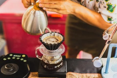 Professional barista preparing coffee using chemex pour over coffee maker and Stock Photos