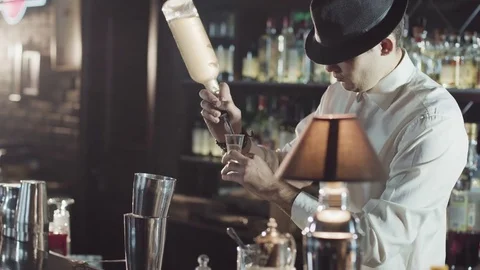 Professional bartender in a black hat is make cocktail in a bar Stock Footage 75231477