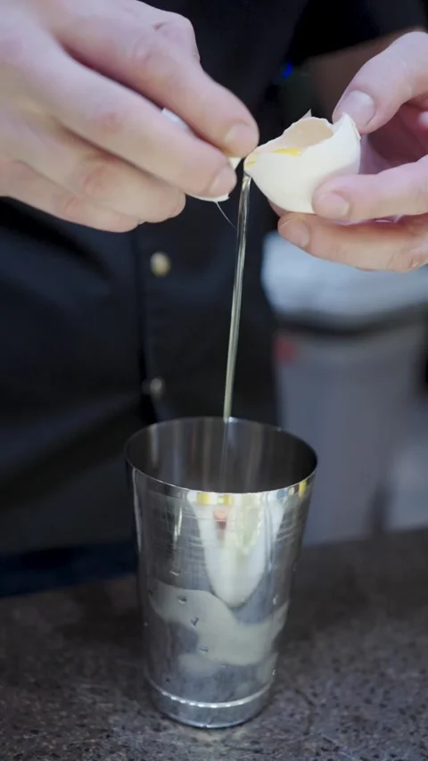 Professional Bartender Cracking Egg into Shaker for Sour Cocktail. Close-up.. Stock Footage 333915126