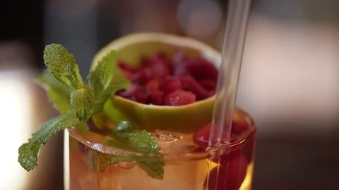 Professional bartender decorating cocktail with lime, raspberry and mint Stock Footage 96145958