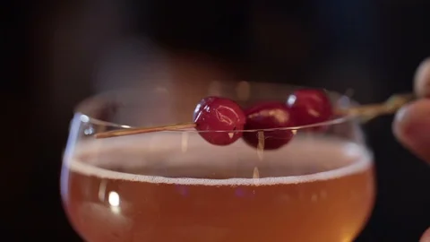 Professional bartender decorating cocktail with raspberry Stock Footage 96146940