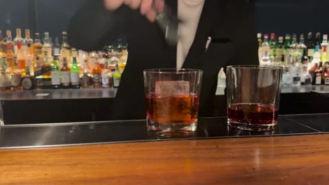 Professional Bartender Placing Large Ice Cubes into Cocktail Glasses Stock Footage 345013981