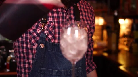 Professional bartender pouring red wine cherry juice in ice filled glass in slow Stock Footage 104373469