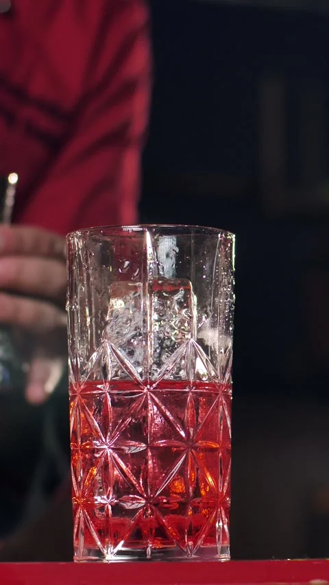 A professional bartender prepares an alcoholic cocktail with ice cubes for Stock Footage 305167468