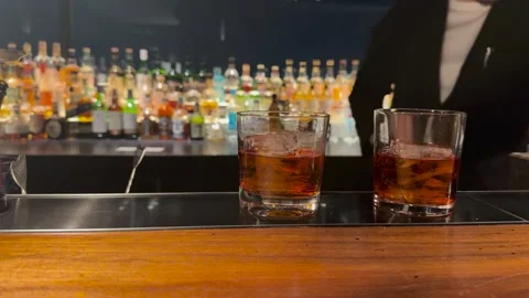 Professional Bartender Preparing Cocktails in a Dimly Lit Japanese Bar 스톡 동영상 345220798