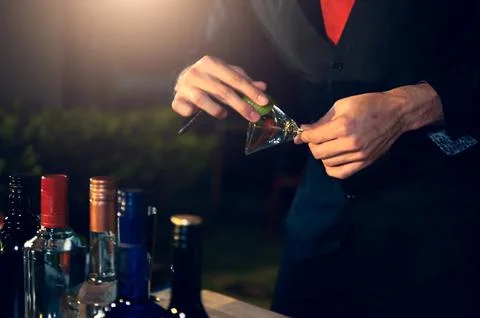 Professional bartender preparing fresh lime lemonade cocktail in drinking w.. Stock-Fotos
