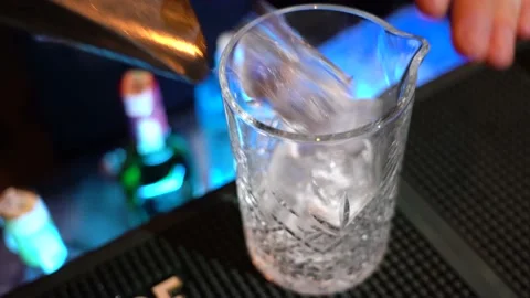 Professional bartender is putting professional crystal ice cubes in glass while Stock Footage 149062923