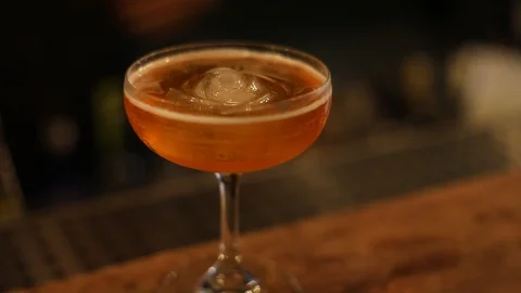 Professional Bartender Putting Sculpture Ice in Cosmopolitan Drink Stock Footage 129846321