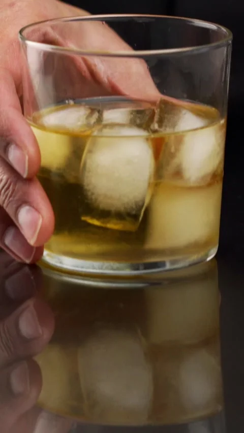 Professional bartender serving a cocktail in the glass with one big ice cube Vídeos de archivo 335240863