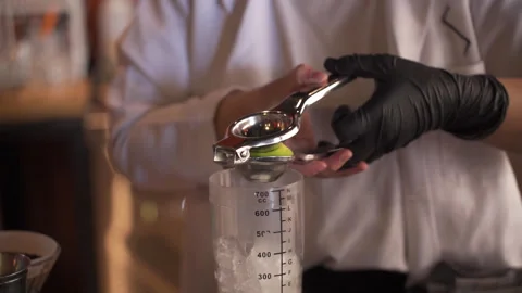 Professional Bartender Squeezing Fresh Lime into Shaker with Ice Stock Footage 330977552