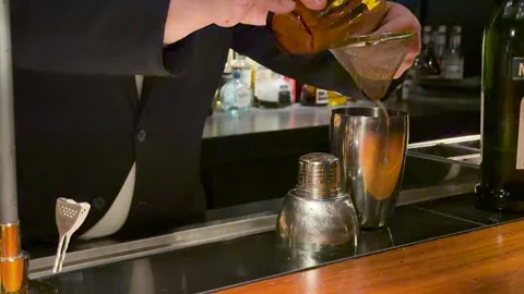 Professional Bartender in Suit Straining Mixed Drink at Japanese Bar Stock Footage 334833643