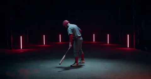 Professional baseball player batter hitting a ball against dark background Stock Footage 105386013