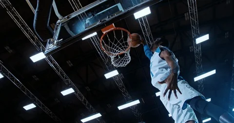 Professional basketball player in action performing slam dunk Stock Footage