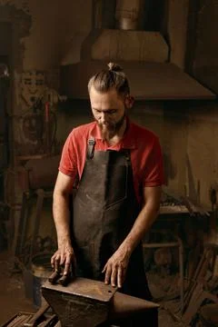 Professional bearded blacksmith in workshop thoughtful portrait Stock Photos