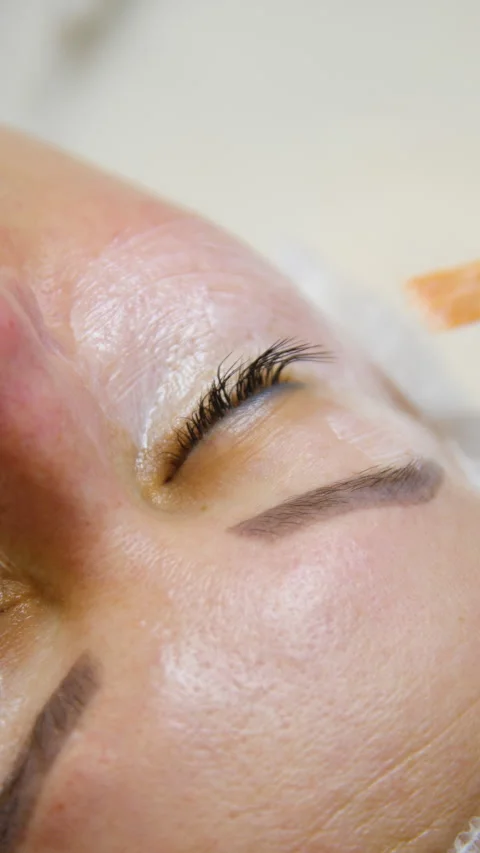 Professional beautician applying cleansing mask on female client&amp;#039;s face. Vídeo Stock 342586666