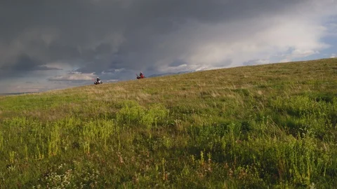 Professional bikers carrying skis while riding motorcycle on green mountain Stock Footage 116743828
