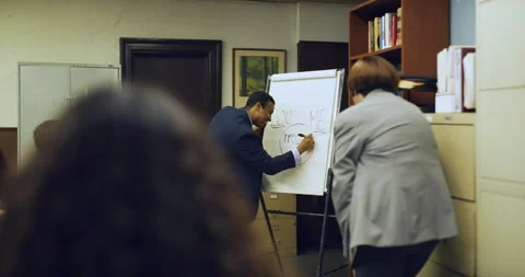 Professional black man leading an exciting group meeting with people cheering in Stock Footage 199463559