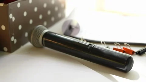 Professional black microphone lies on a white desk in sunlight Stock Footage 335579933