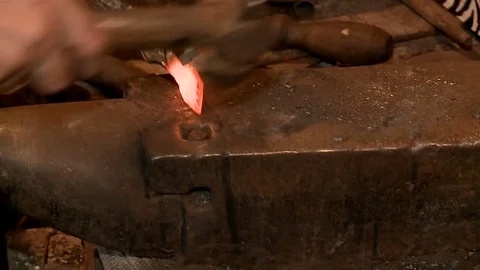 Professional blacksmith has an effort on glowing hot metal and sparks fly Video stock 75160092