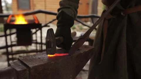 Professional Blacksmith knocks on red-hot metal Stock Footage 168944868