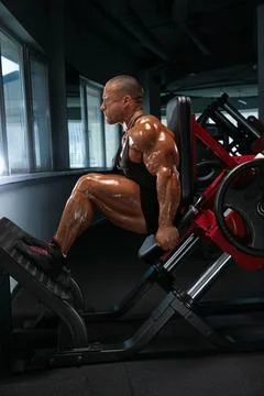 Professional bodybuilder executes a leg press exercise in a high end gym Stock Photos