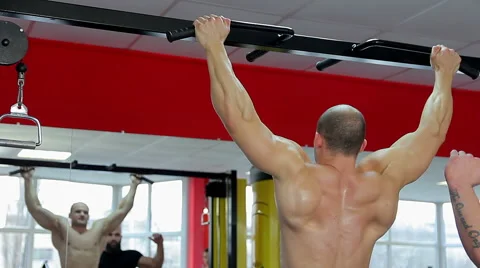 Professional bodybuilder with muscular body doing pull-ups, training with coach Video stock 65402082
