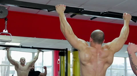 Professional bodybuilder with muscular body doing pull-ups, training with coach Video stock 65402671