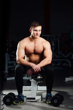 Professional bodybuilder sitting on the bench, resting between exercises with Stock Photos