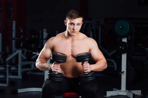 Professional bodybuilder sitting on the bench, resting between exercises with Stock-Fotos