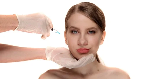 Professional botox injection on the cheekbone of a young woman at  clinic 動画素材 85569618