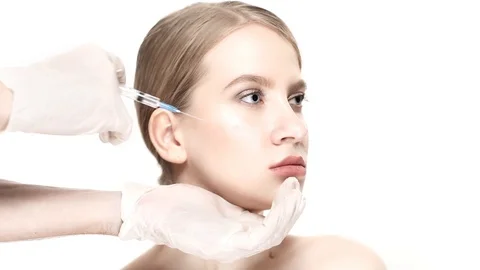 Professional a botox injection in cheekbones then the woman smiles Video stock 88287632