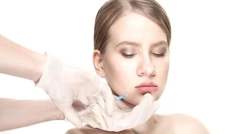 Professional botox injection into the lower lip of the beautiful woman. She get 스톡 동영상 88287637