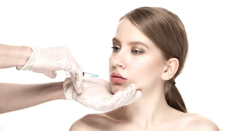 Professional botox injection into the lower lip of the beautiful woman Stock-Footage 88287639
