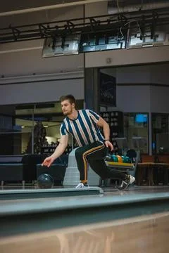 Professional bowler throws his throw and is in position to watch his ball. Bo Stock Photos