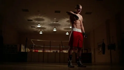 A professional boxer in the background of the ring, flexing his hands before Stock Footage 83968434