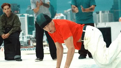 Professional break dancer doing head spin at roof top with city view. Endeavor. 스톡 사진