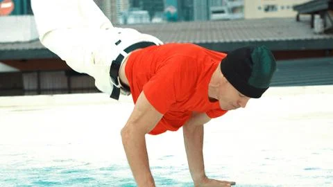 Professional break dancer doing head spin at roof top with city view. Endeavor. Foto stock