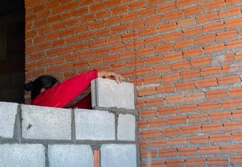Professional bricklayer building a brick wall with mortar and trowel. Stock Photos
