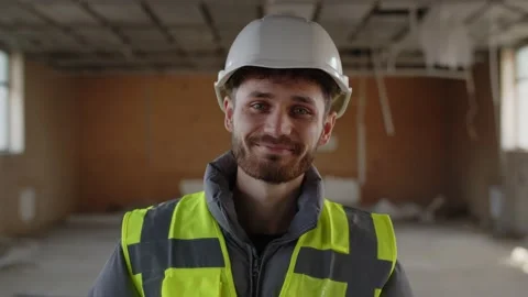 Professional builder in front of a construction site posing with smile Stock Footage 236772880